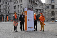 Vier Frauen und ein Mann stehen mit einem Poster des Zonta Club auf dem Burgplatz vor dem Neuen Rathaus und Stadthaus