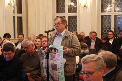 Ein Bürger spricht am Mikrofon während einer Diskussionsveranstaltung zum Standort des Leipziger Freiheits- und Einheitsdenkmals.