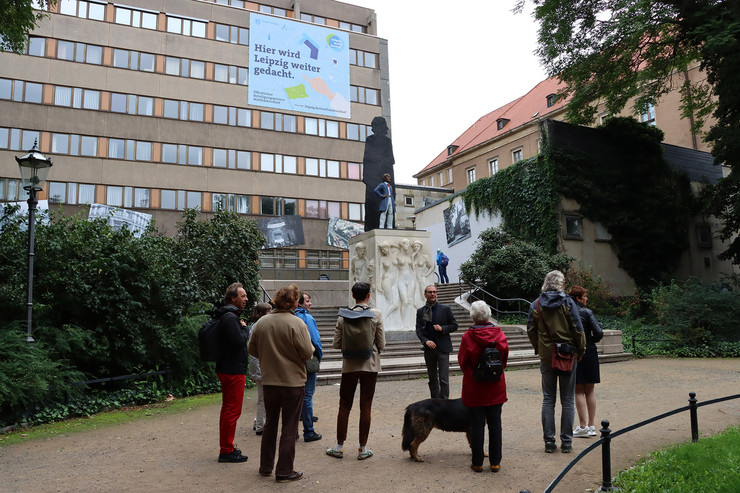 Eine kleine Gruppe von Menschen steht auf dem Matthäikirchhof und lauscht einer Führung