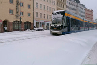 hoher Schnee, stehende Straßenbahn auf verschneitem Gleis, im Hintergrund Stadthäuser