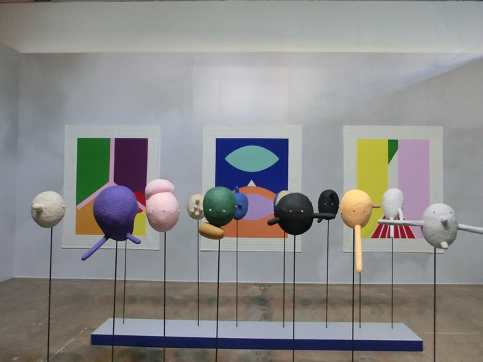 Ansicht eines Kunstobjekts zeitgenössischer Kunst: farbige kreisrunde Objekte auf Metallstäben