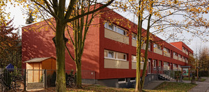 Zweigeschossiges, rotbraunes Gebäude einer Kindertagesstätte im Grünen. 