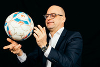 Mann mit Brille hält einen Fußball