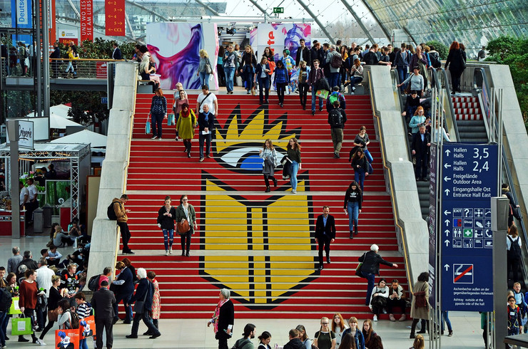 Leipziger Buchmesse, vereinzelte Messebesucher stehen auf Treppe der Messe mit Buchmesse-Logo