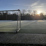 Fußballfeld mit Tor auf der Sportplatzanlage Nonnenwiese. Die Sonne geht auf und es ist Raureif auf dem Platz.
