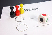Symbolischer Stimmzettel mit schwarzer, roter und gelber Mensch-ärgere-Dich-nicht-Figur