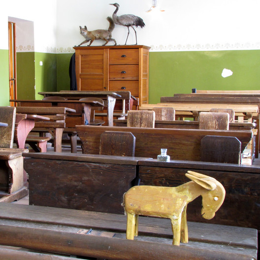 Blick in das Klassenzimmer Volksschule um 1900. Im Vordergrund die so genannte Eselsbank zur Bestrfung von Schülern.