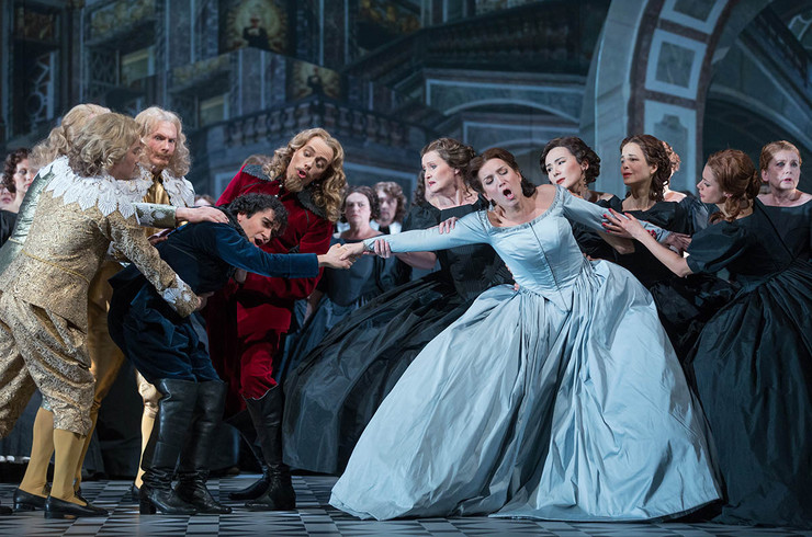 Szene aus der Oper "Der Rebell des Königs". Die Schauspieler haben barocke Kleider an und die Männer Perücken. Ein Mann und eine Frau halten sich an den Händen und werden von anderen Schauspielern auseinander gezogen.