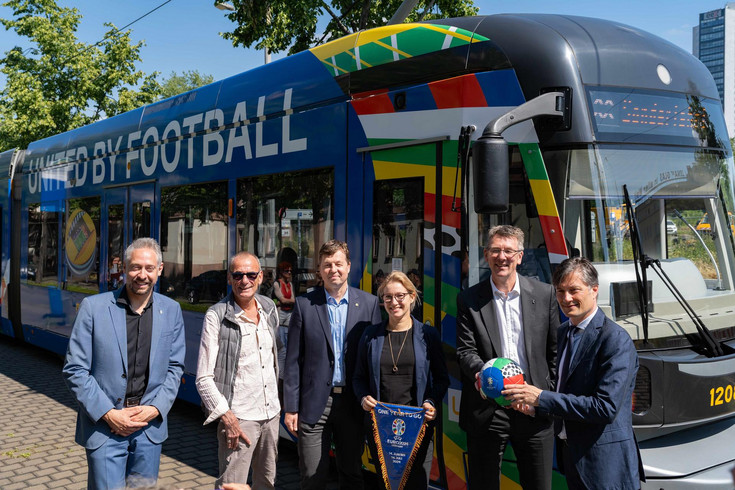 Sportbürgermeister Heiko Rosenthal und weitere Menschen stehen vor einer Straßenbahn im Design der UEFA EURO 2024