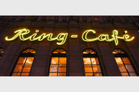 Leuchtende Leuchtreklame Ring-Café an einer Gebäudefassade in der Nacht.