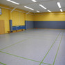 Innenansicht Sporthalle Lützschena mit Spielfläche, Basketballkorb und Bänken