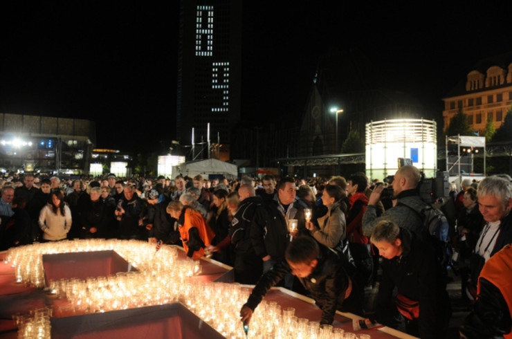Viele Besucher auf dem Augustusplatz beim Lichtfest. Aus Kerzen wird eine 89 geformt.