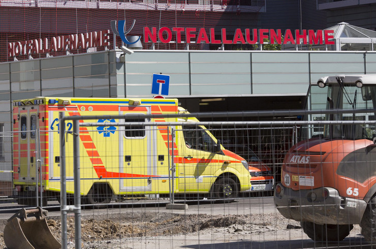 Krankenwagen am Eingang der Notfallaufnahme des Universitätsklinikums Leipzig. Davor ein Bauzaun und ein Teil eines Baggers.