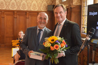 Der Integrationsbeauftragte Stojan Gugutschkow erhält zur Verabschiedung ein Buch und einen Blumenstrauß von Oberbürgermeister Burkhard Jung