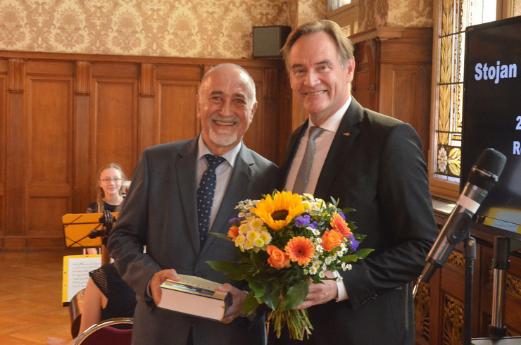 Der Integrationsbeauftragte Stojan Gugutschkow erhält zur Verabschiedung ein Buch und einen Blumenstrauß von Oberbürgermeister Burkhard Jung