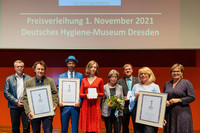 Eine Gruppe Menschen steht im Dresdner Hygienemuseum mit präsentierten Auszeichnungen in der Hand zum "Sächsischen Museumspreis 2021"