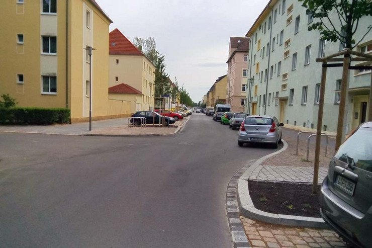Sanierte Demmeringstraße mit Häusern und parkenden Autos