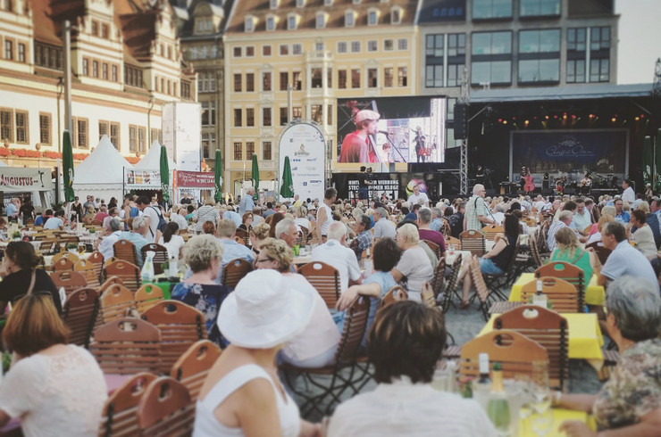 Zuschauer bei den Classic Open auf dem Leipziger Markt sitzen an Tischen und schauen Richtung Bühne