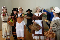 Kinder in historischen Kostümen spielen eine Marktszene von früher nach
