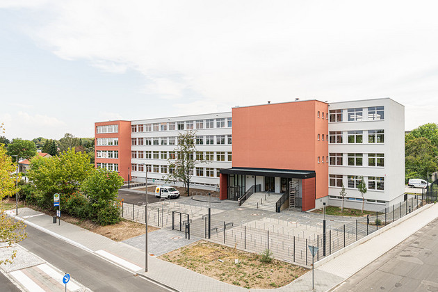Außenansicht des Schulgebäude der Höltystraße mit einem mehrstöckigen Schulbau und vielen Fahrradbügeln davor. 
