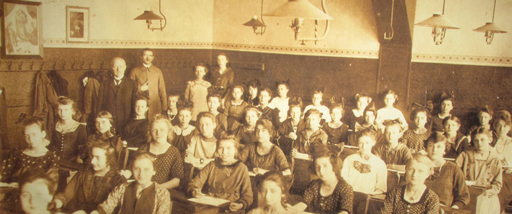Klassenfoto einer Mädchenklasse mit Lehrern im Klassenzimmer, um 1925