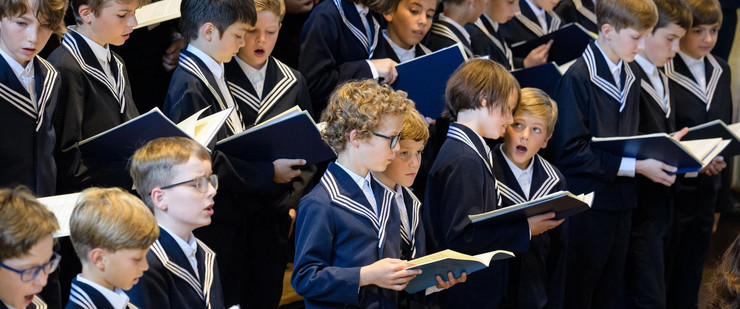 Junge Thomaner singen in ihren blauen Matrosenanzügen auf der Chorempore der Thomaskirche in Leipzig.