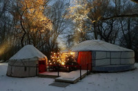 Zwei Zelt-Jurten im Schnee mit einem Weihnachtsbaum