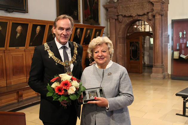 Oberbürgermeister Jung neben Verena von Mitschke-Collande. Er hält den Blumenstrauß, sie die Ehrenmedaille.