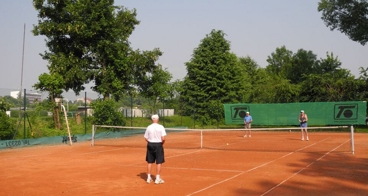 Drei Männer stehen auf einem Tennisplatz uns spielen Tennis.