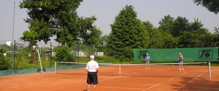 Drei Männer stehen auf einem Tennisplatz uns spielen Tennis.