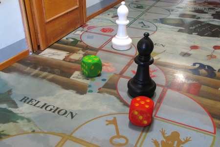 Das Flurspiel in der zweiten Etage ermöglicht das spielerische Entdecken der Dauerausstellung. Fußboden als Spielfläche mit zwei Spielfiguren und Würfeln.