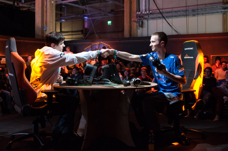 Zwei Computerspieler reichen sich bei einem Turnier die Hand