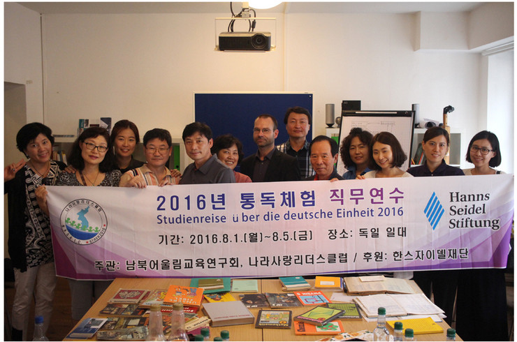 Teilnehmer eine südkoreanischen Delegation im Leipziger Schulmuseum. Die Teilnehmer halten ein Banner in den Händen.