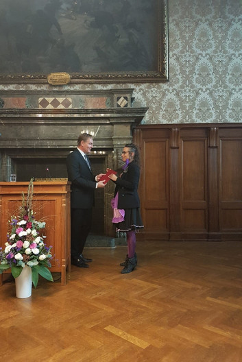 Oberbürgermeister Burkhard Jung überreicht einer jungen Frau eine Urkunde.