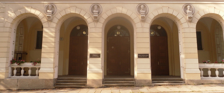 Eingangsbereich einer Schuler mit drei Türen, die von mehreren Torbögen überspannt sind.