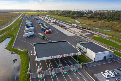LKW Terminal von CargoBeamer mit mehreren abgestellten LKW-Anhängern und einem Gleisanschluss.