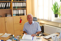 Porträt des Volkshochschul-Leiters Rolf Sprink an seinem Schreibtisch