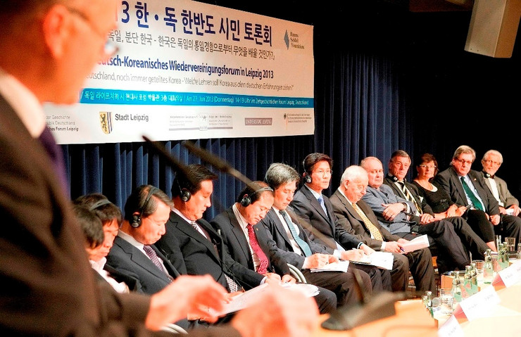 Blick ins Plenum, deutsche und koreanische Teilnehmer auf der Bühne beim Deutsch-Koreanischen Wiedervereinigungsforum 2013 in Leipzig