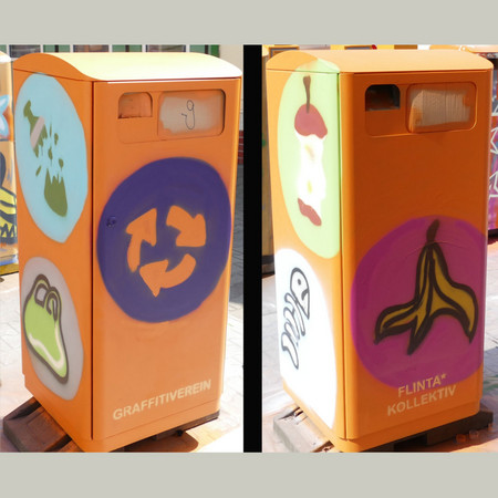 Abfallbehälter mit Graffiti-Motiv, verschiedene Abfälle wie zum Beispiel eine Fischgräte, ein Plastetüte, eine Bananenschale und ein Apfelkriebsch