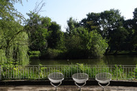 Terasse des Inselteichs mit drei Sesseln und Ausblick auf den Teich