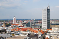 Blick von oben über Leipzig. Man sieht das Cityhochhaus, das Messehochhaus, das Paulinum und die Nikolaikirche.