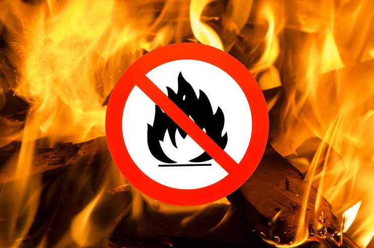 Flammen eines flackernden Lagerfeuers mit eingefügtem Piktogramm offenes Feuer verboten