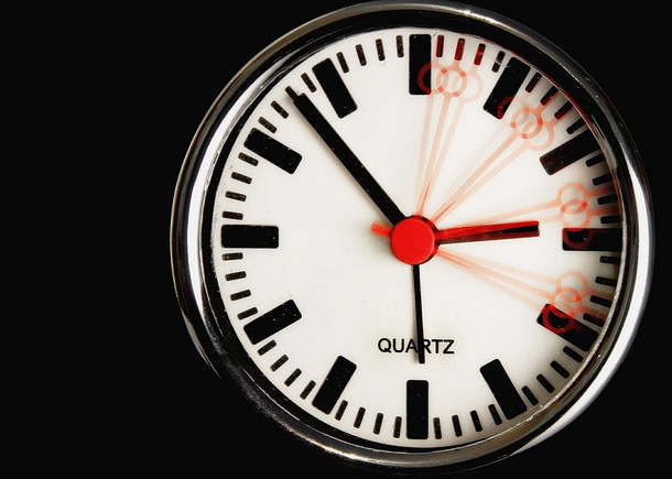 Nahaufnahme einer Uhr mit verschiedenen Positionen des roten Sekundenzeigers.