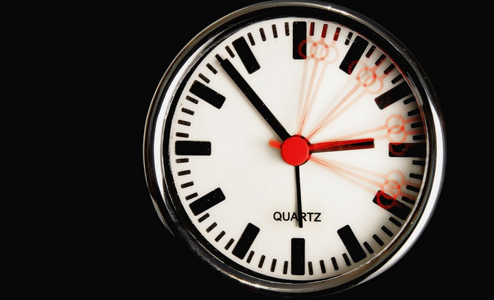 Nahaufnahme einer Uhr mit verschiedenen Positionen des roten Sekundenzeigers.