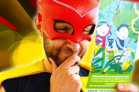 Ein Mann mit roter Superhelden Maske hält einen Flyer in der Hand