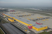 Luftaufnahme des DHL-Luftfrchtzentrums Leipzig. man sieht die riesige gelb-rote DHL-Halle, daneben jede Menge gelbe Flugzeuge.