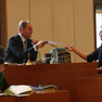 Ein junger Mann in schwarzem Hemd und mit schwarzem Schal übergibt dem sitzenden Oberbürgermeister Burkhard Jung ein Schriftstück