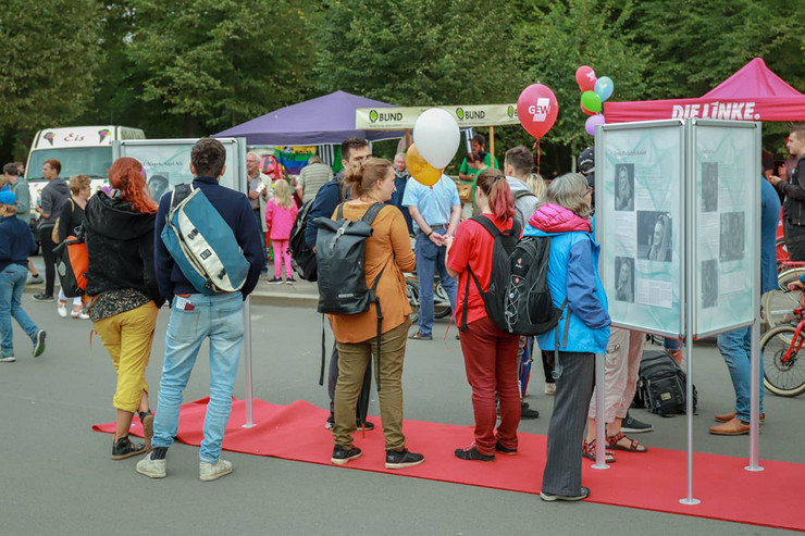 Besucher schauen sich die Infotafeln der Ausstellung "Straße der Demokratie" auf dem Brückenfest 2018 an.