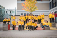 Viele Kinder des Spatzenchores der Schola Cantorum in gelben T-Shirts auf einem Schulhof