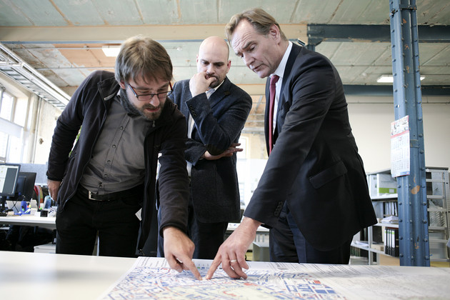 Oberbürgermeister Burkhard Jung steht mit Ingmar Reichert und Florian Finkenstein in einem Büro vor einer Karte und schauen auf diese. Herr Jung und einer der beiden anderen Männer zeigen mit dem Finger auf einen bestimmten Bereich.